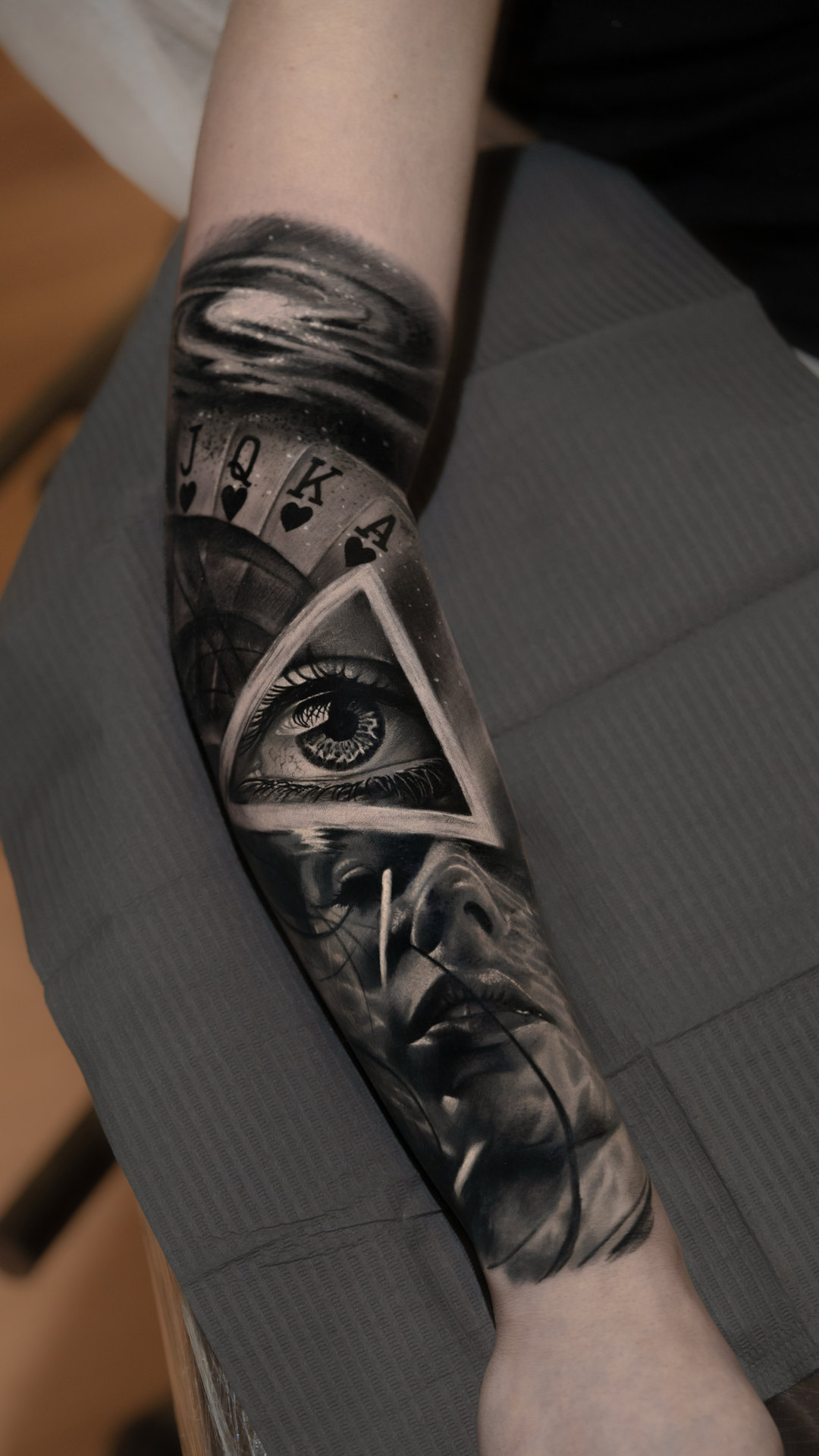 Black-and-gray geometric eye forearm tattoo by Tony Vilella