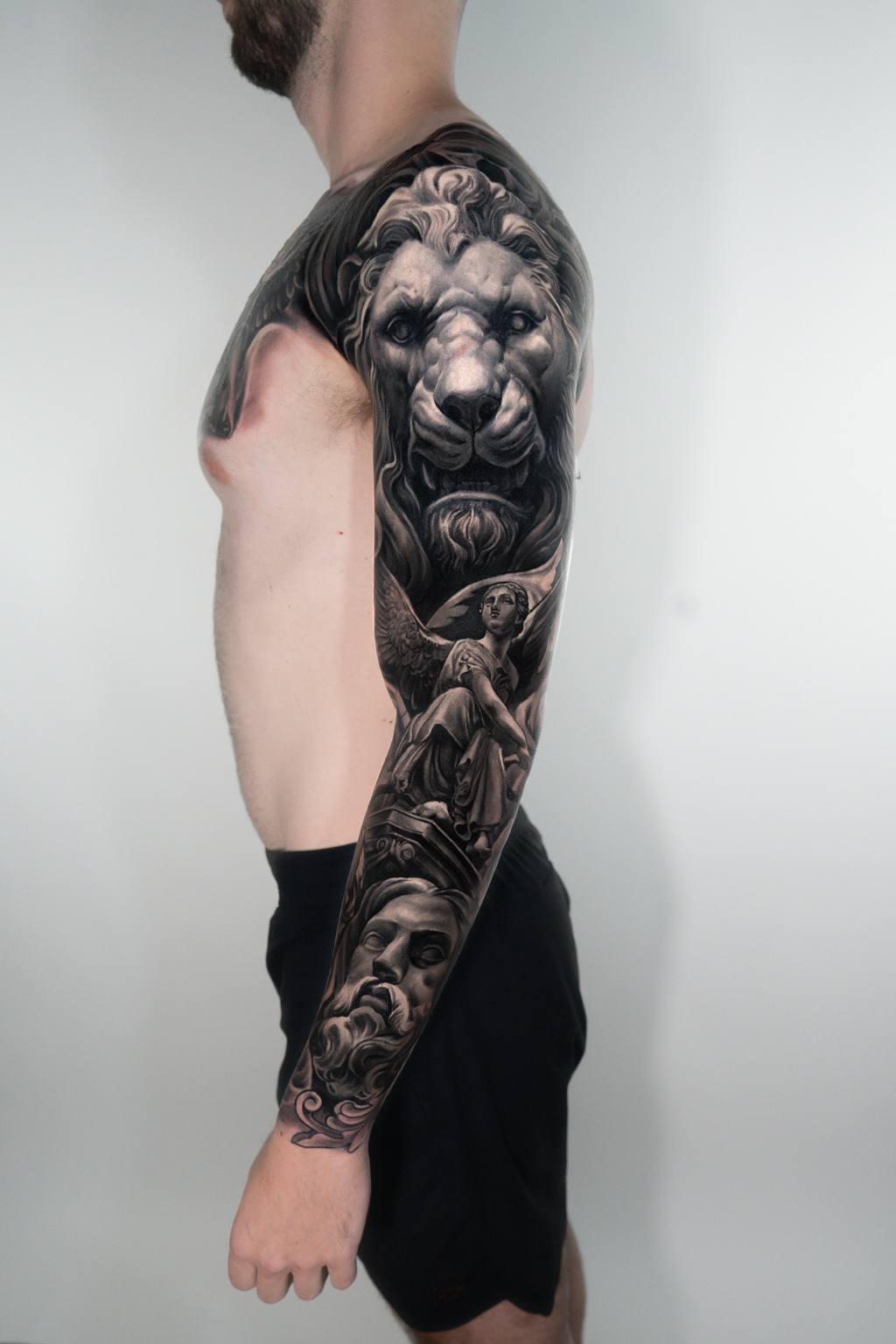 Black-and-gray lion realism sleeve tattoo by Tony Vilella
